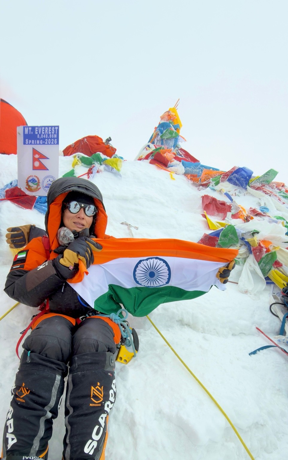 Shradha Gupta holding the Indian flag at the summit of Mount Everest