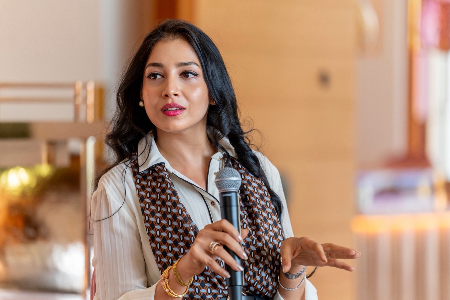 Shradha Gupta speaking at an engagement, holding a microphone